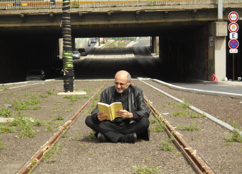 Pierre Martial lance l'opération "Lire Partout!", en lisant au beau milieu du boulevard des Maréchaux à Paris, entre les rails du tramway